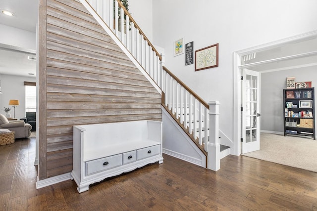 staircase with a high ceiling, baseboards, hardwood / wood-style floors, and recessed lighting