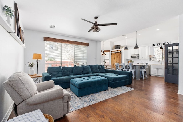 living room featuring dark wood-style floors, ceiling fan, visible vents, and recessed lighting