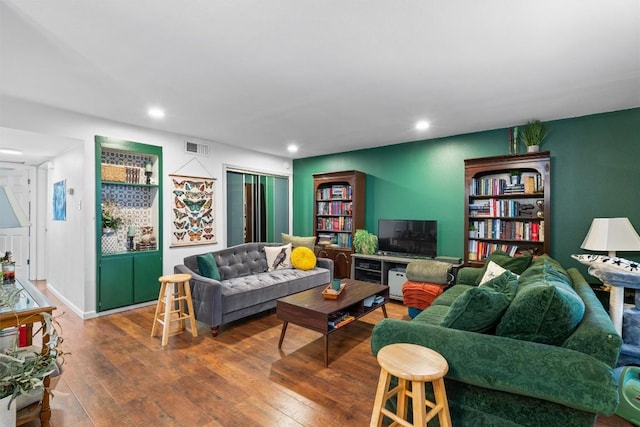 living area featuring baseboards, visible vents, hardwood / wood-style floors, and recessed lighting