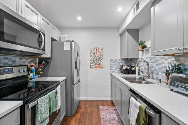 2401 Leon St Unit 208, Austin, TX 78705 - kitchen featuring appliances with stainless steel finishes, a sink, dark wood-type flooring, backsplash, and visible vents