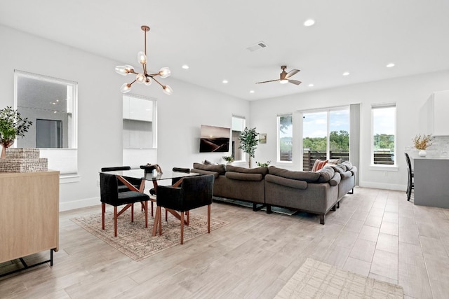 living area with recessed lighting, baseboards, visible vents, light wood-type flooring, and ceiling fan with notable chandelier