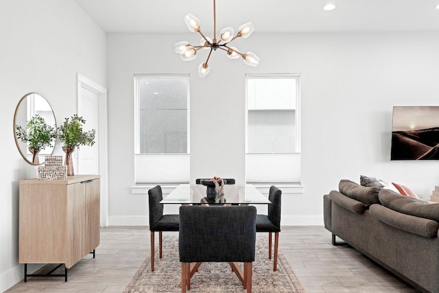 dining area with baseboards, recessed lighting, light wood-style flooring, and an inviting chandelier