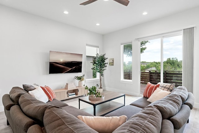 living area with recessed lighting, ceiling fan, light wood-style flooring, and baseboards