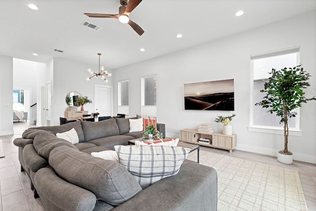 living area with a healthy amount of sunlight, ceiling fan with notable chandelier, visible vents, and recessed lighting