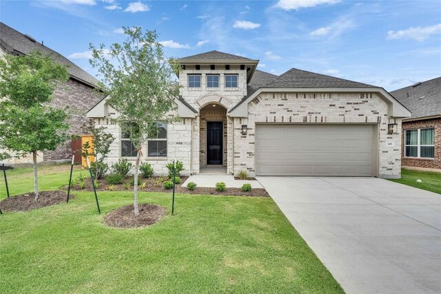 148 Rocky View Ln, Georgetown, TX 78628 - french country home featuring an attached garage, concrete driveway, a front lawn, a shingled roof, and brick siding