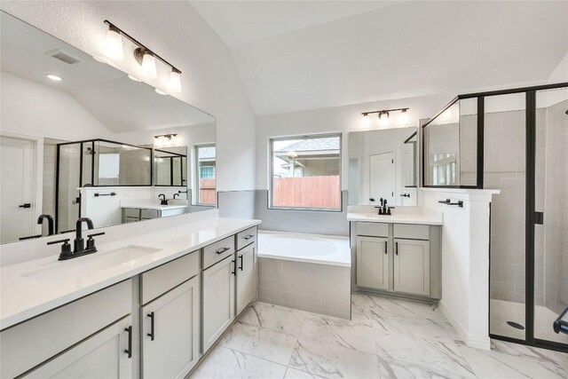 148 Rocky View Ln, Georgetown, TX 78628 - bathroom featuring vaulted ceiling, a shower stall, a bath, two vanities, and marble look tiles
