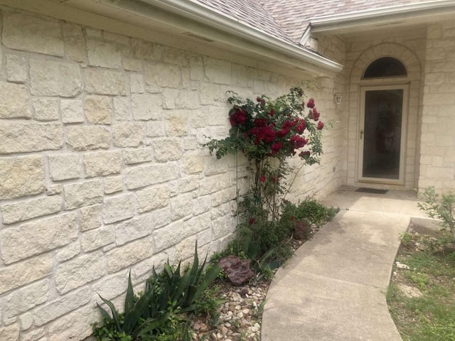 entrance to property featuring a shingled roof