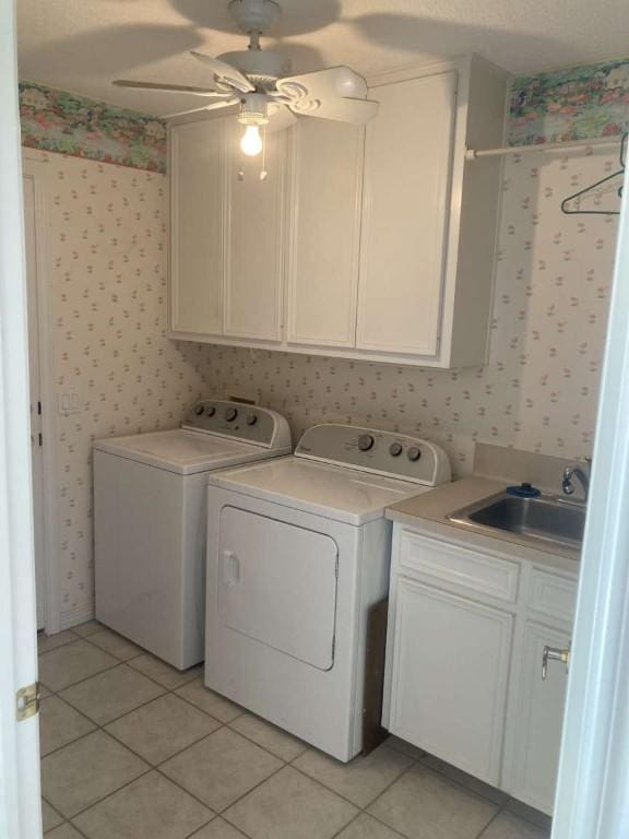 washroom with light tile patterned floors, washer and clothes dryer, a sink, and wallpapered walls