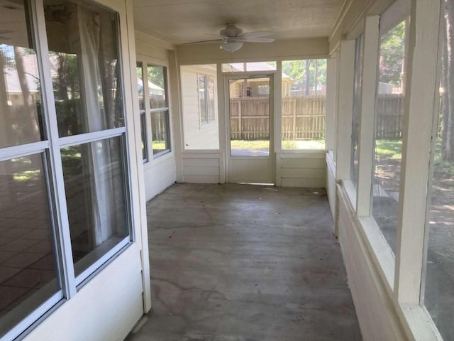 unfurnished sunroom featuring a ceiling fan