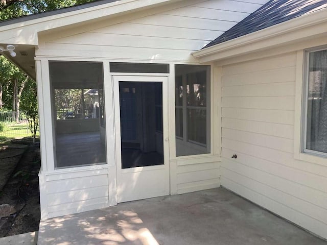 entrance to property featuring a patio area and fence