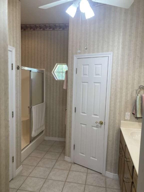 bathroom featuring ceiling fan, a stall shower, tile patterned floors, and wallpapered walls