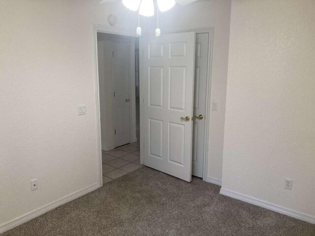 carpeted spare room featuring baseboards