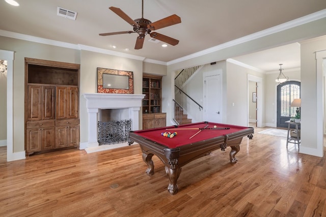 game room featuring light wood finished floors, baseboards, visible vents, and a fireplace with raised hearth