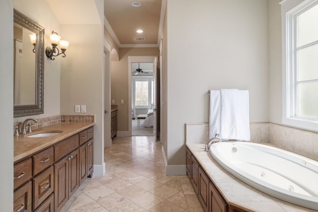 full bath featuring visible vents, a ceiling fan, vanity, baseboards, and a tub with jets