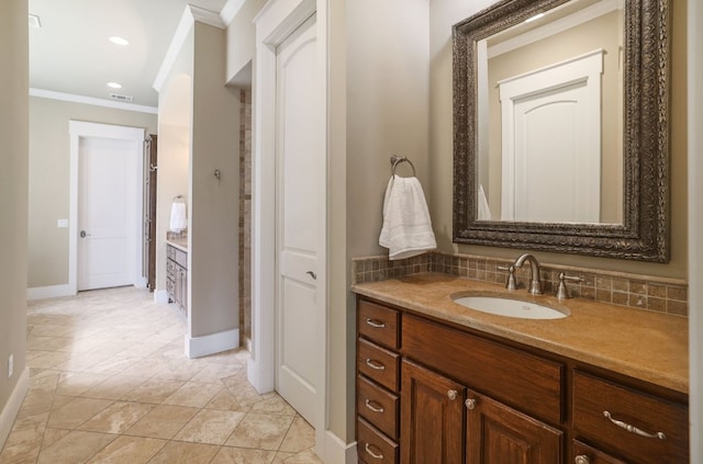 bathroom with baseboards, crown molding, vanity, and decorative backsplash