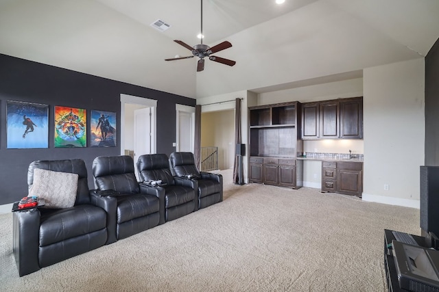 cinema featuring light carpet, baseboards, visible vents, ceiling fan, and high vaulted ceiling