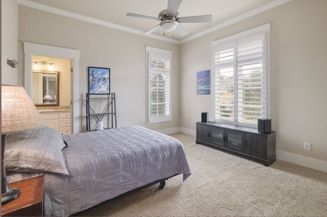 carpeted bedroom featuring a ceiling fan, ensuite bath, baseboards, and crown molding