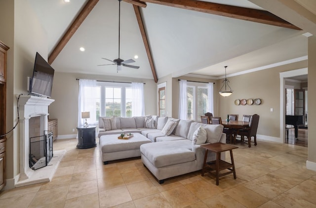 living area featuring baseboards, a fireplace with raised hearth, and beamed ceiling