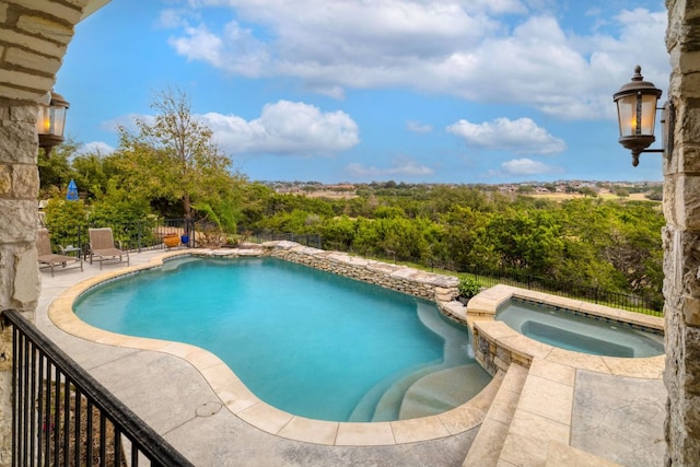 view of swimming pool featuring a patio, fence, and a pool with connected hot tub