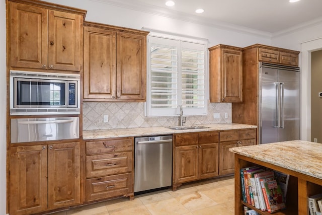 kitchen featuring built in appliances, a warming drawer, brown cabinets, a sink, and backsplash