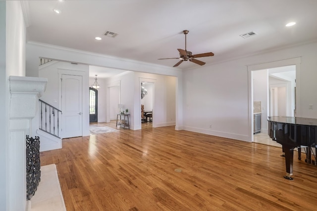 unfurnished living room featuring visible vents, light wood finished floors, crown molding, and ceiling fan with notable chandelier