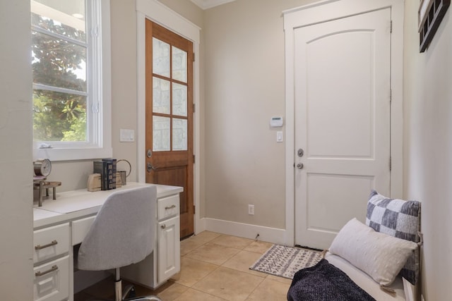 office space with built in study area, light tile patterned floors, and baseboards