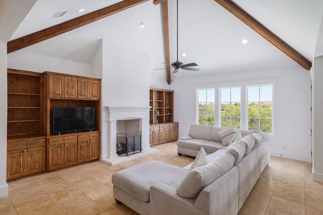 living room featuring a fireplace with raised hearth, a ceiling fan, baseboards, light tile patterned floors, and beamed ceiling