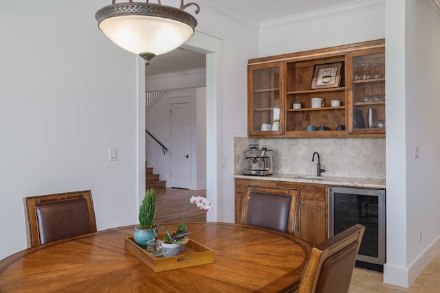 dining area with wet bar, crown molding, stairway, baseboards, and beverage cooler