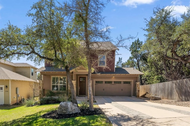 view of front of property with concrete driveway, an attached garage, fence, stone siding, and a front lawn