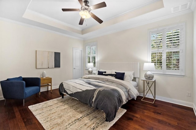 bedroom featuring a tray ceiling, visible vents, dark wood finished floors, and baseboards