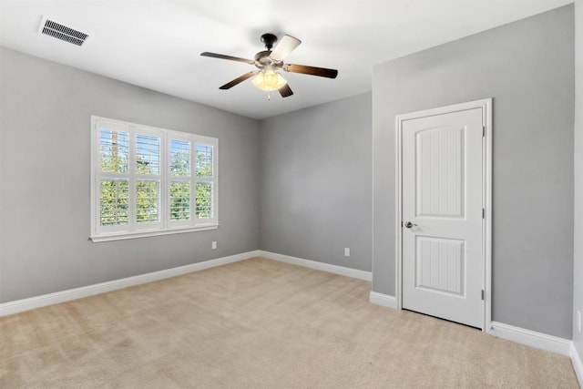 unfurnished room with baseboards, visible vents, a ceiling fan, and light colored carpet