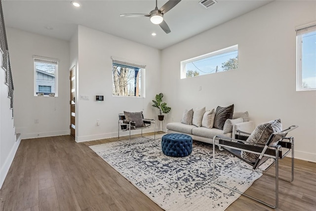 living area featuring baseboards, wood finished floors, visible vents, and recessed lighting