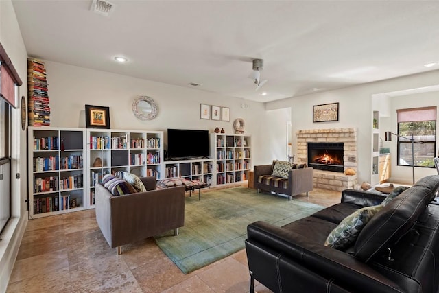 living room featuring a fireplace, visible vents, and recessed lighting