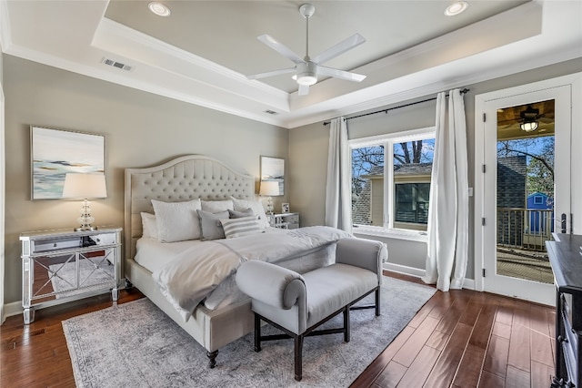 bedroom with dark wood-style floors, access to outside, visible vents, and a raised ceiling