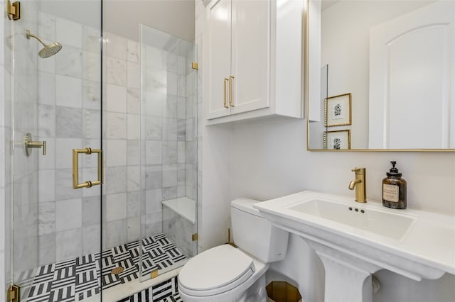 bathroom with a sink, a shower stall, and toilet