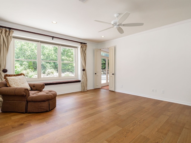 living area featuring baseboards, a ceiling fan, light wood-style flooring, ornamental molding, and recessed lighting