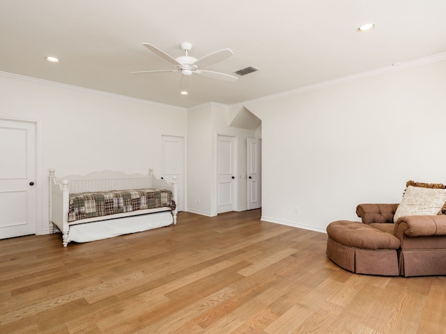 living area with baseboards, ceiling fan, ornamental molding, and light wood-style floors