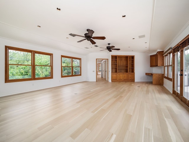 unfurnished living room with light wood-style floors, baseboards, visible vents, and a wealth of natural light