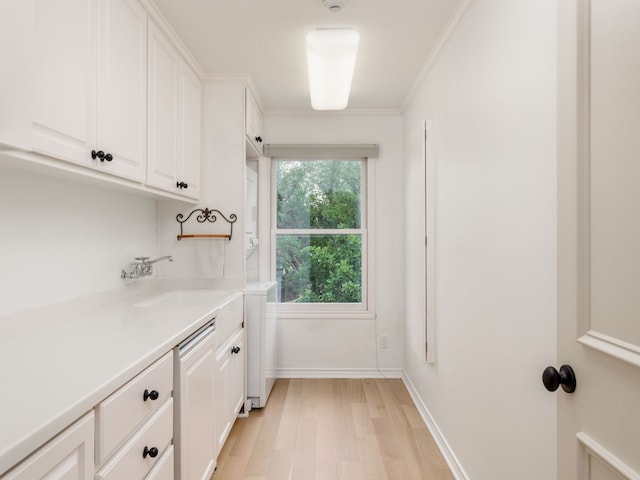 interior space with light wood-type flooring, baseboards, a sink, and ornamental molding