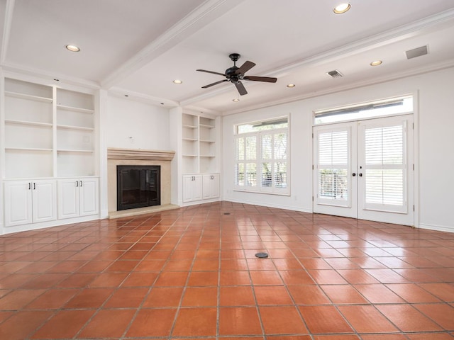 unfurnished living room featuring built in features, a glass covered fireplace, crown molding, and baseboards