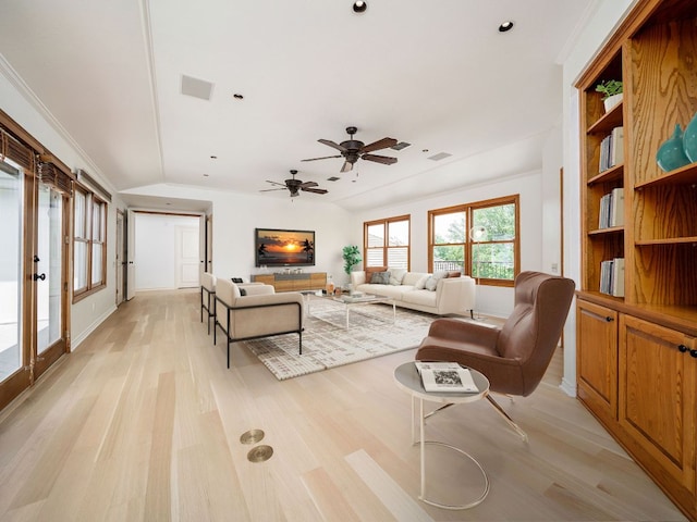 living room featuring visible vents, ornamental molding, vaulted ceiling, ceiling fan, and light wood-type flooring