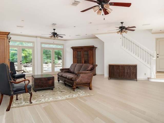 living area featuring french doors, crown molding, visible vents, stairway, and light wood-style floors