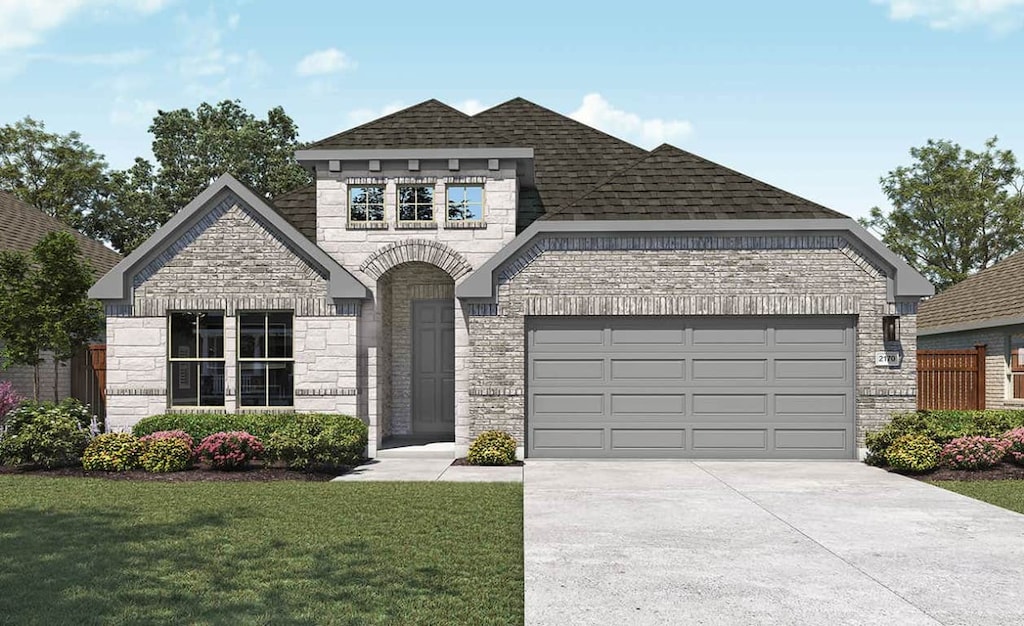 french country home with roof with shingles, an attached garage, a front yard, stone siding, and driveway