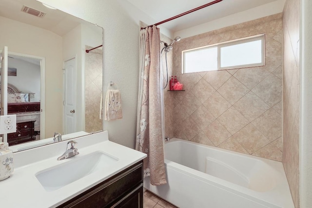 ensuite bathroom featuring ensuite bathroom, vanity, visible vents, tile patterned floors, and shower / bath combination with curtain