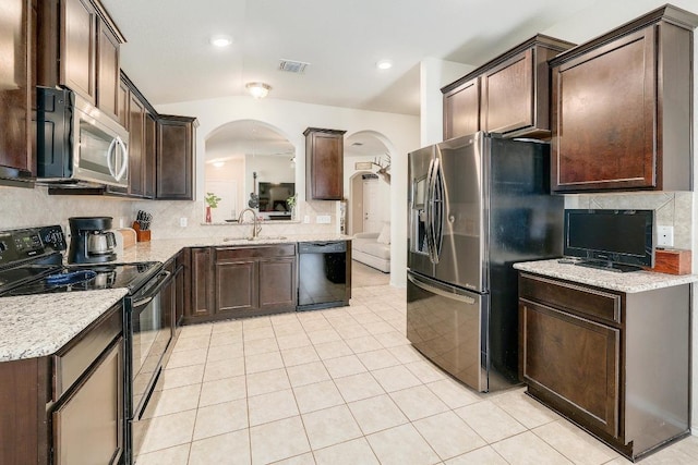 kitchen with tasteful backsplash, light tile patterned flooring, a sink, dark brown cabinets, and black appliances