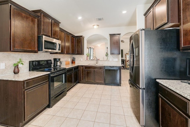 kitchen featuring light tile patterned floors, black appliances, dark brown cabinets, and decorative backsplash