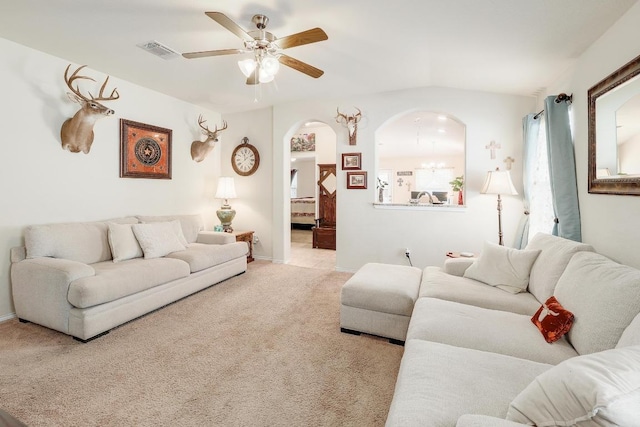 living room with arched walkways, ceiling fan, visible vents, baseboards, and carpet