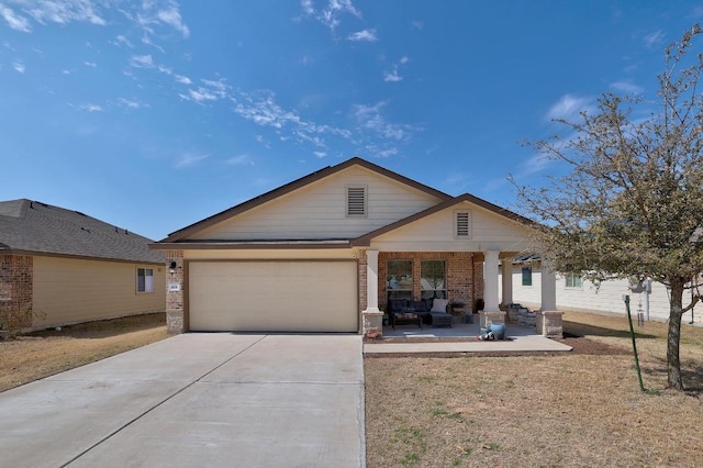 view of front of home featuring driveway, brick siding, an attached garage, and a front yard