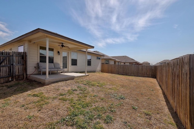 back of property with a yard, a fenced backyard, ceiling fan, and a patio