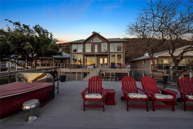 back of house at dusk featuring a balcony